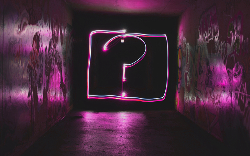 Ein großes Neon-Fragezeichen am Ende eines dunklen Tunnels als Symbol für "Ich weiß nicht was ich will!"
